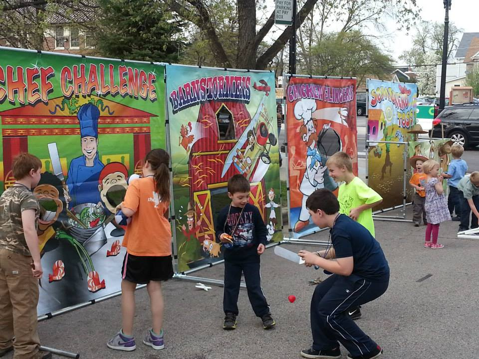 Carnival game booth rentals with colorful backdrops for school events